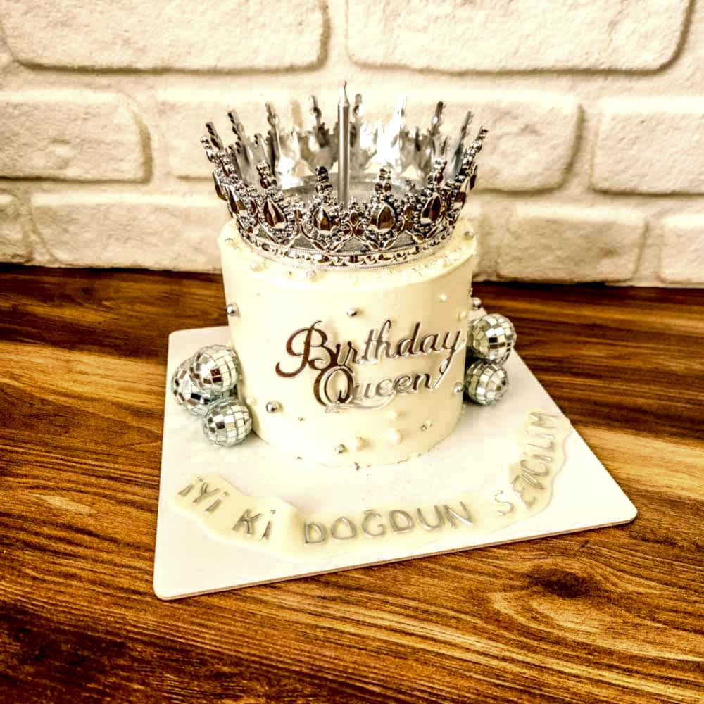 Gümüş simlerle parlayan beyaz pasta, üstünde zarif taç figürüyle kraliçe gibi kutlamalar için tasarlandı.