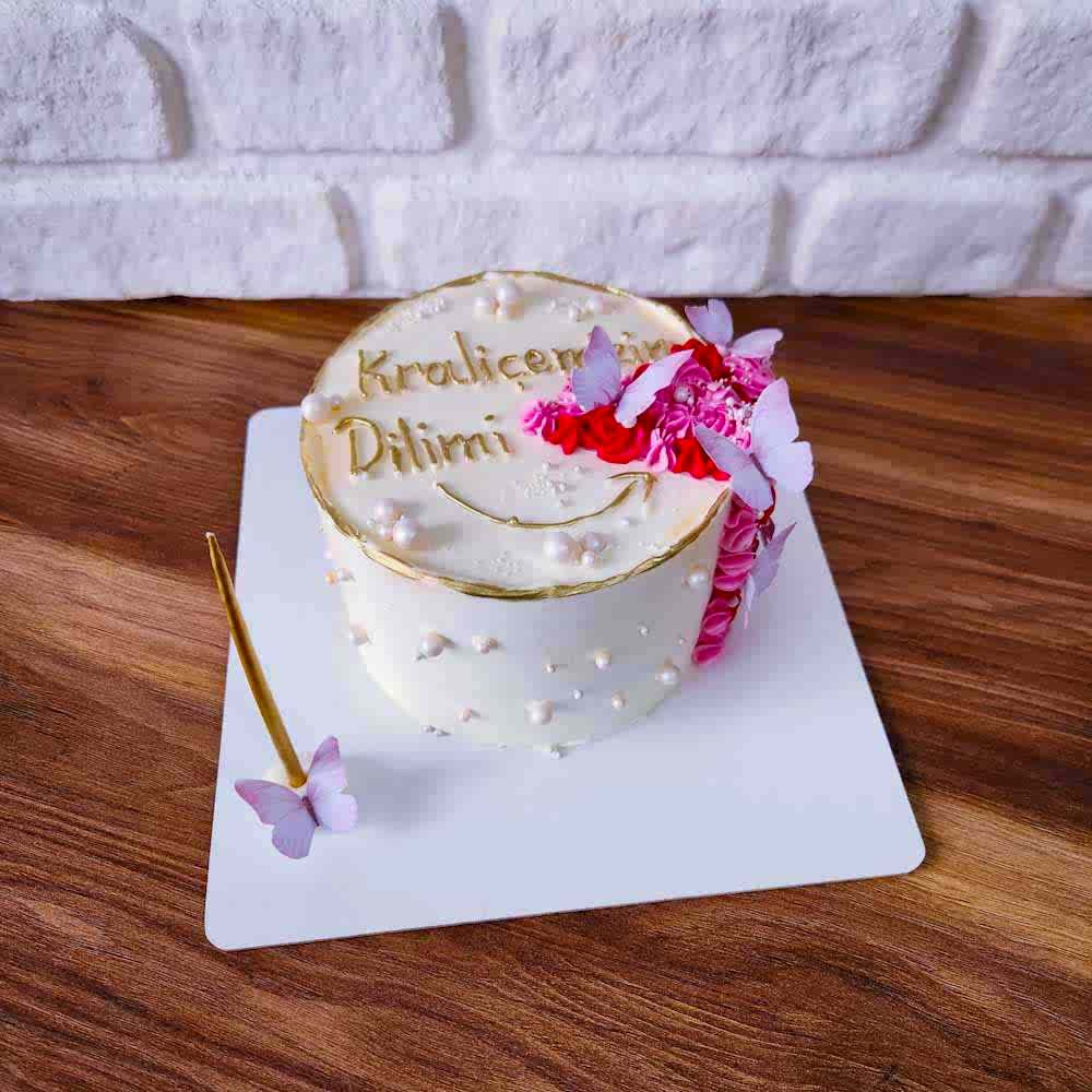 “Kraliçemizin Dilimi” yazılı butik pasta, zarif detaylarla süslenmiş; sevgiyle öne çıkarılan bir kadına özel, hem esprili hem duygusal bir tasarım. İster doğum günü ister yıldönümü için, kraliçeye layık bir dilim!