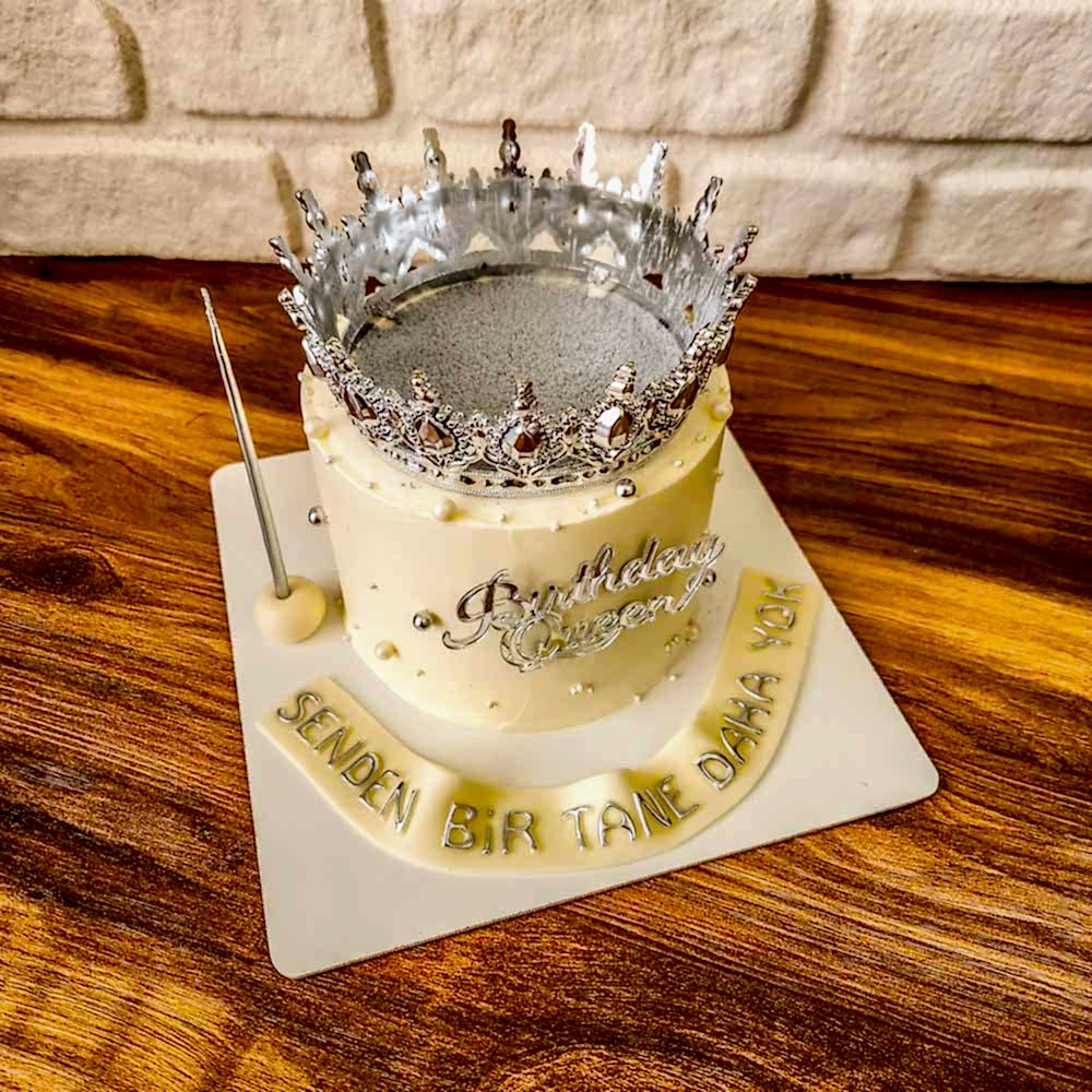 Gümüş simlerle parlayan beyaz pasta, üstünde zarif taç figürüyle kraliçe gibi kutlamalar için tasarlandı.