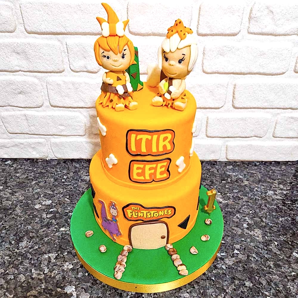 Çakıl ve Bambam figürleriyle süslenmiş taş devri temalı butik pasta. Sevimli ve nostaljik kutlamalara özel tasarım.