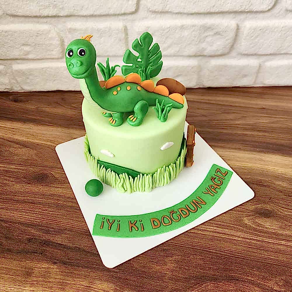 Renkli ve sevimli dinozor figürleriyle süslenmiş butik pasta. Minik kaşiflere özel doğum günü sürprizi!
