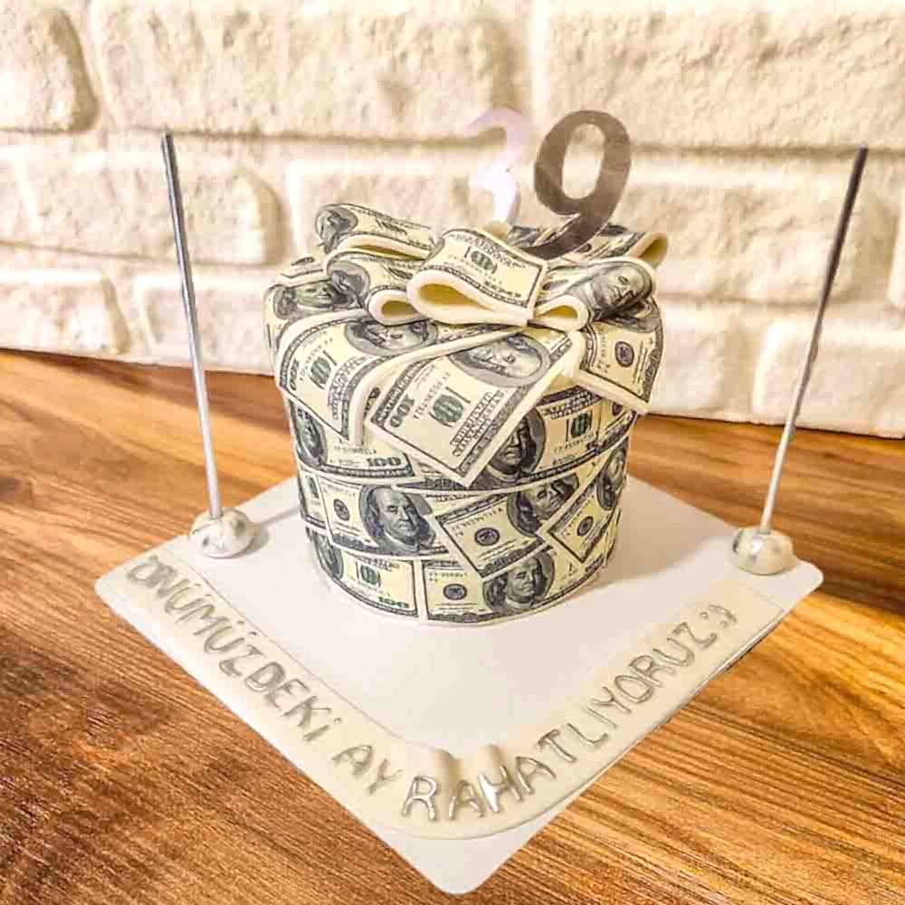 Dolar figürleriyle süslenmiş mizahi butik pasta. Sürpriz kutlamalarda esprili ve dikkat çekici bir tercih.