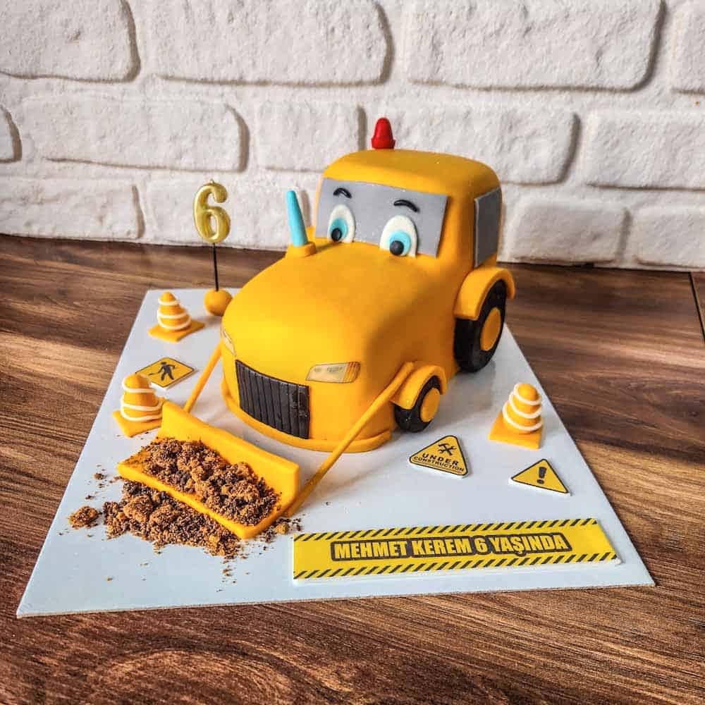 Minik kepçe figürüyle süslenmiş, inşaat temalı eğlenceli butik pasta. Doğum günlerinde tam gaz mutluluk!