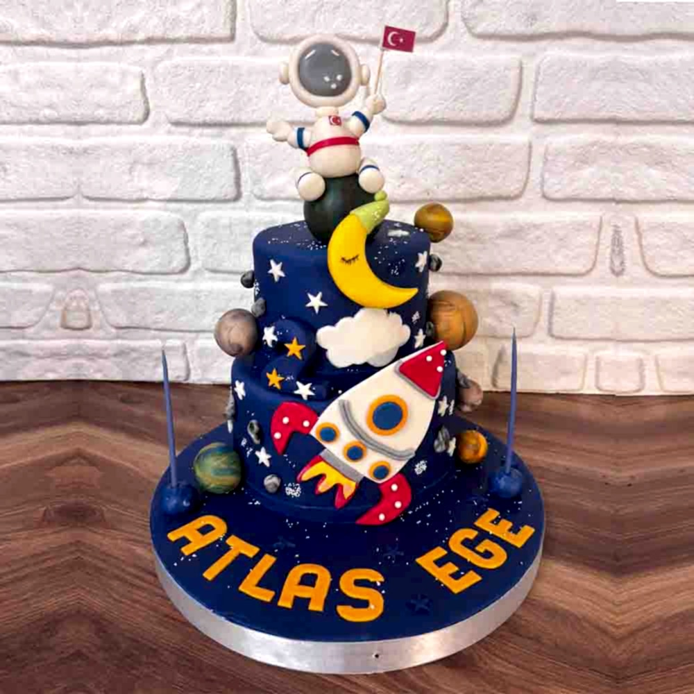Lacivert zeminli, gezegenler, yıldızlar, astronot ve uzay mekiği figürleriyle süslenmiş butik pasta. Uzay tutkunlarına özel galaksi temalı kutlama.