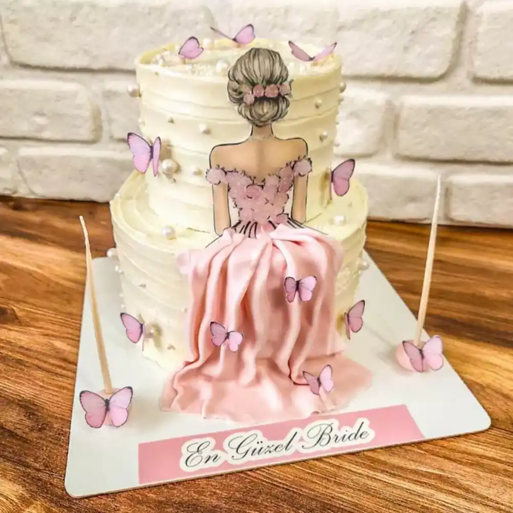 “Bride to Be” yazılı butik pasta, zarif pembe tonlar, inci detayları ve gelin temalı süslemelerle hazırlanmış; bekarlığa veda veya bridal shower kutlamaları için romantik ve neşeli bir tasarım.