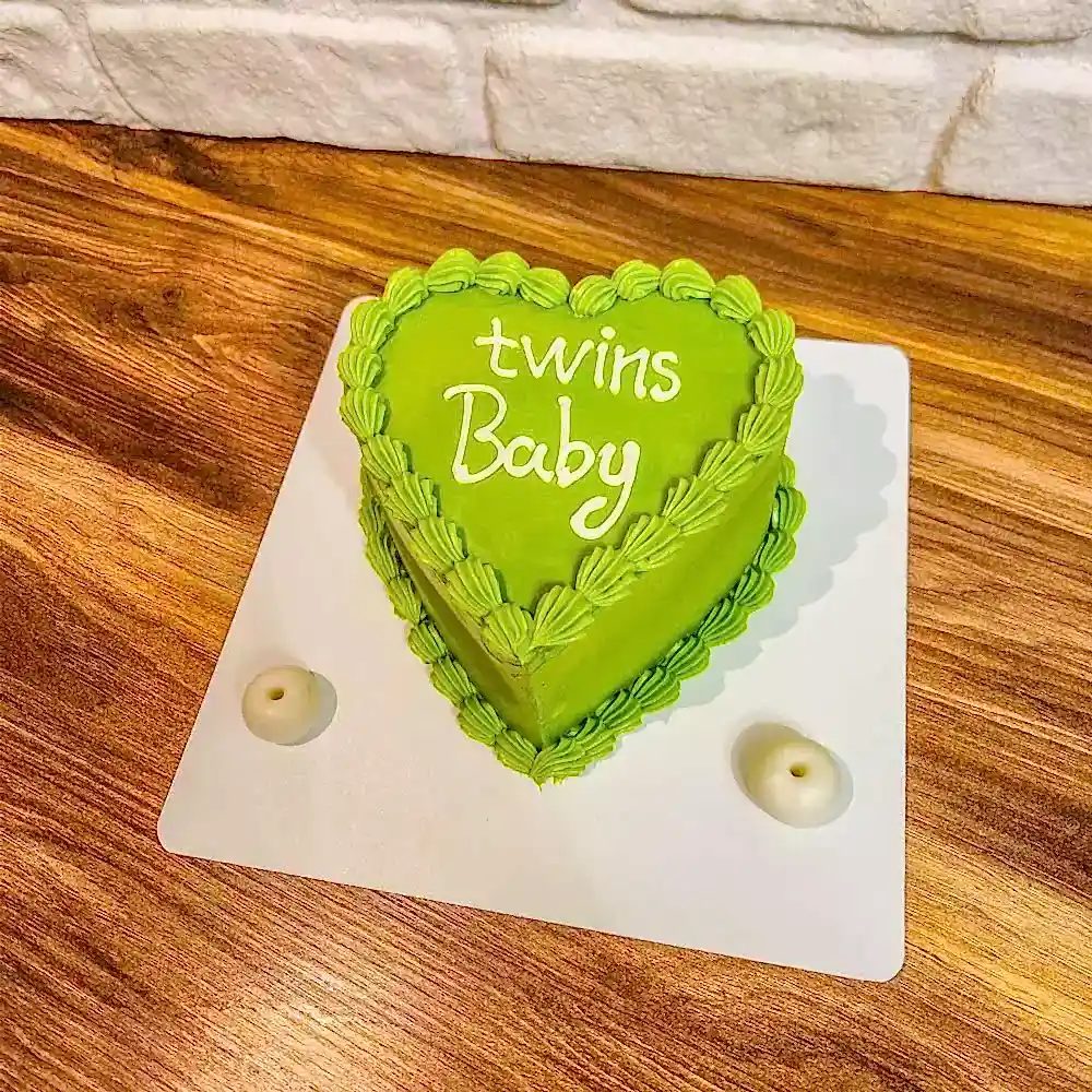 “Twins Baby” yazılı butik pasta, ikiz bebek kutlamalarına özel olarak tasarlanır; pembe ve mavi tonlar, minik ayak izleri veya bebek figürleriyle süslenmiş neşeli ve sevimli bir tasarım sunar.