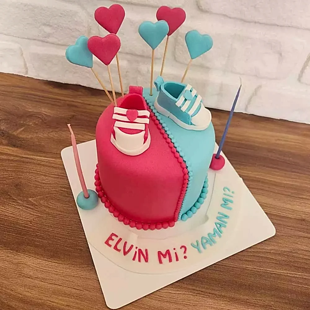 Cinsiyet sürprizi anına özel, pembe ve mavi detaylarla süslenmiş butik pasta. Merak dolu kutlamalara tatlı bir dokunuş!