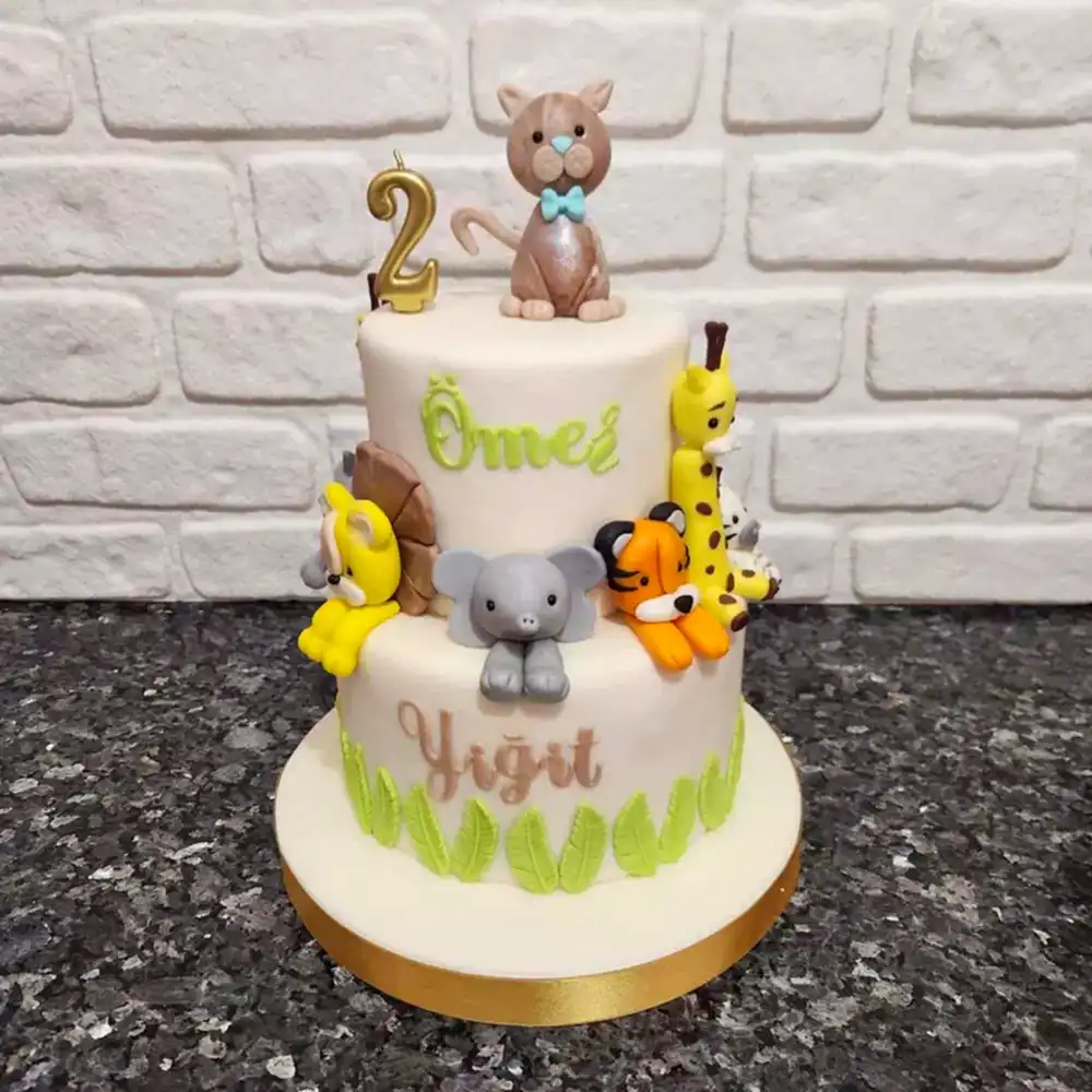Safari temalı hayvan figürleriyle süslenmiş renkli butik pasta. Vahşi doğaya özel eğlenceli kutlama.